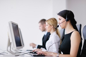 Customer care reps sitting at the computer helping customers