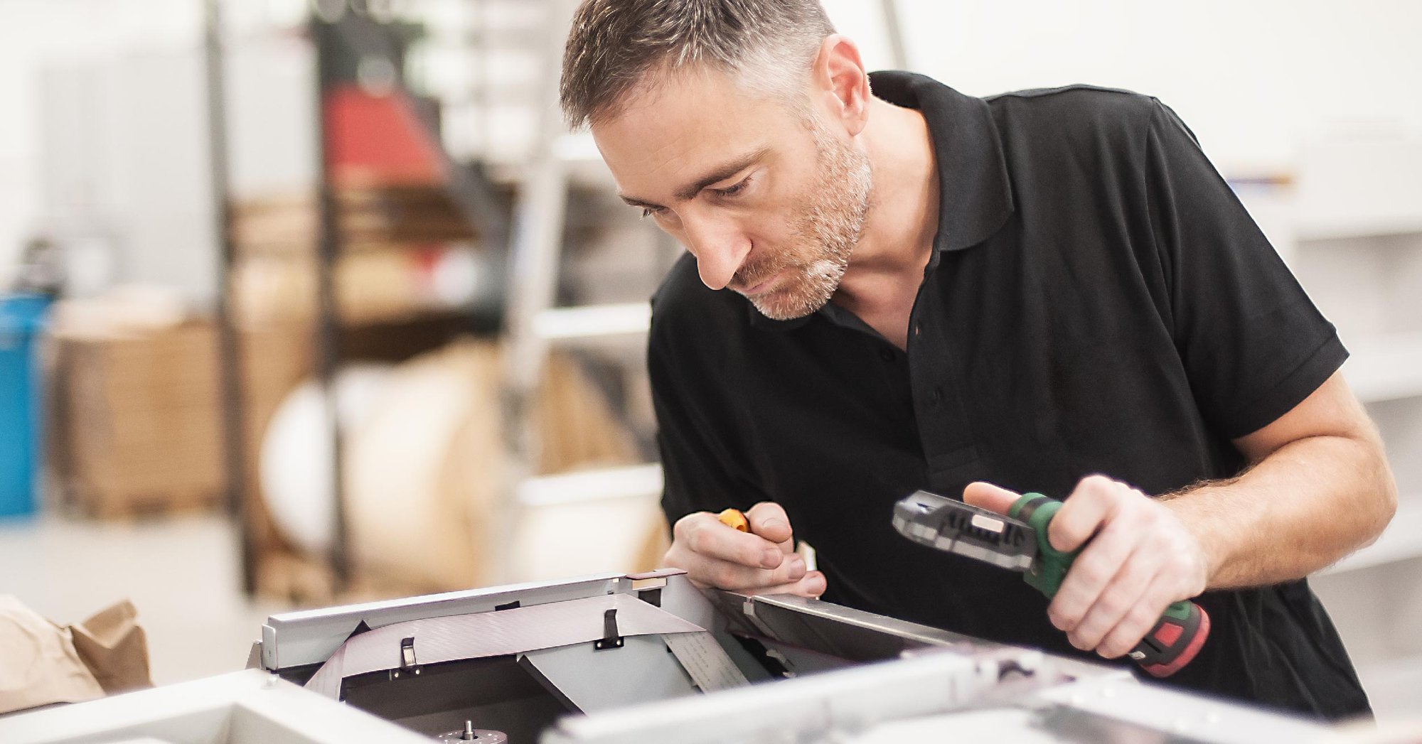 A print technician working on an office printer.