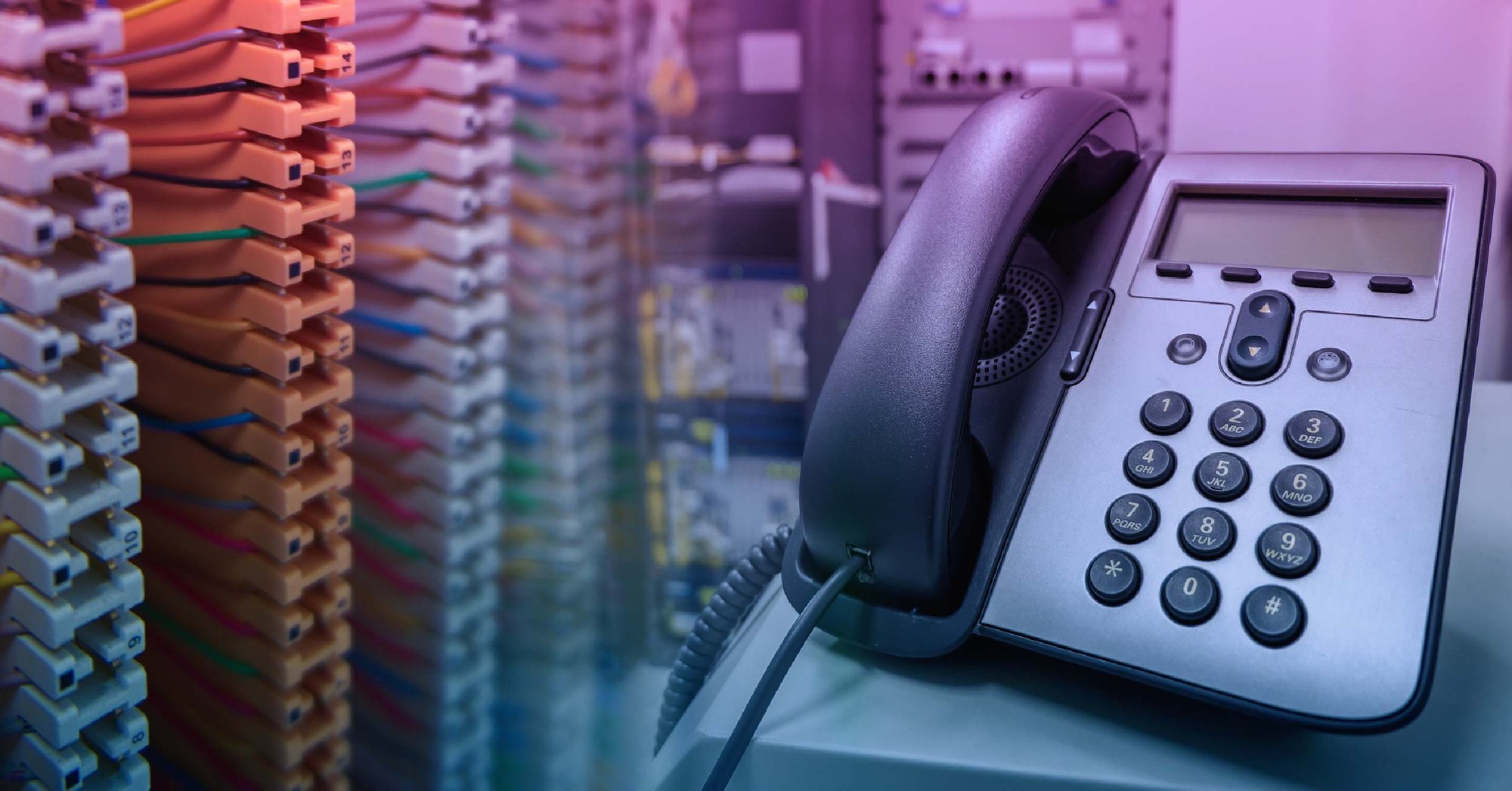 Traditional PBX phone system next to a server rack.