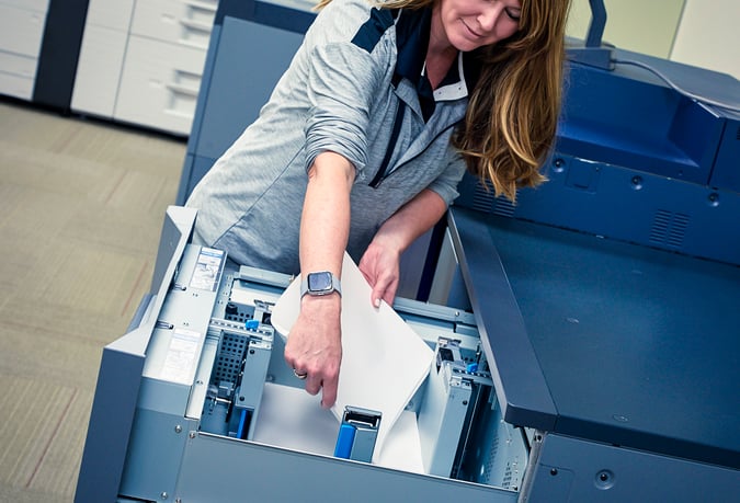 woman replacing paper in printer