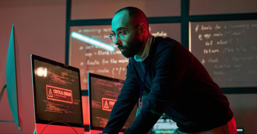 A male cybersecurity pro responds to a critical error on his computer screen.