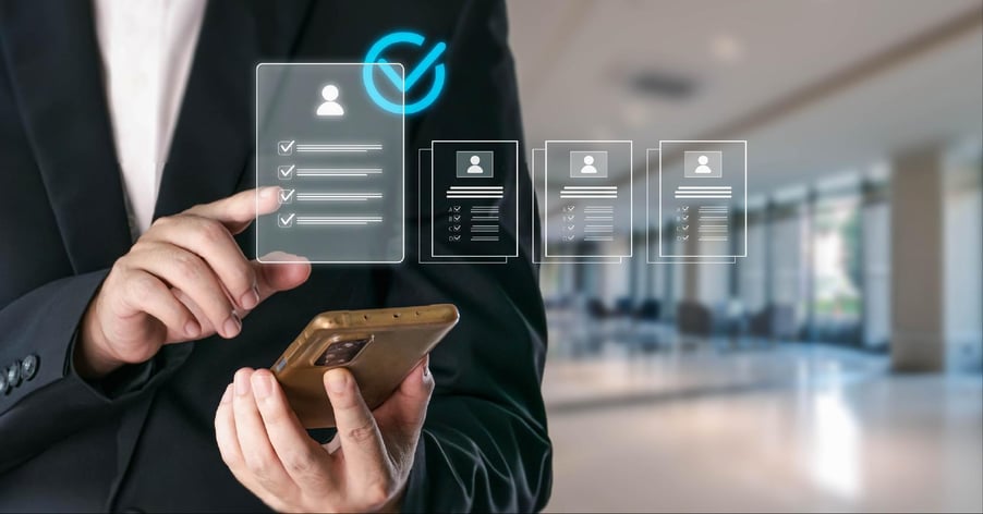 A male executive holds a smart phone under a depiction of an assessment of mulitple vendors.