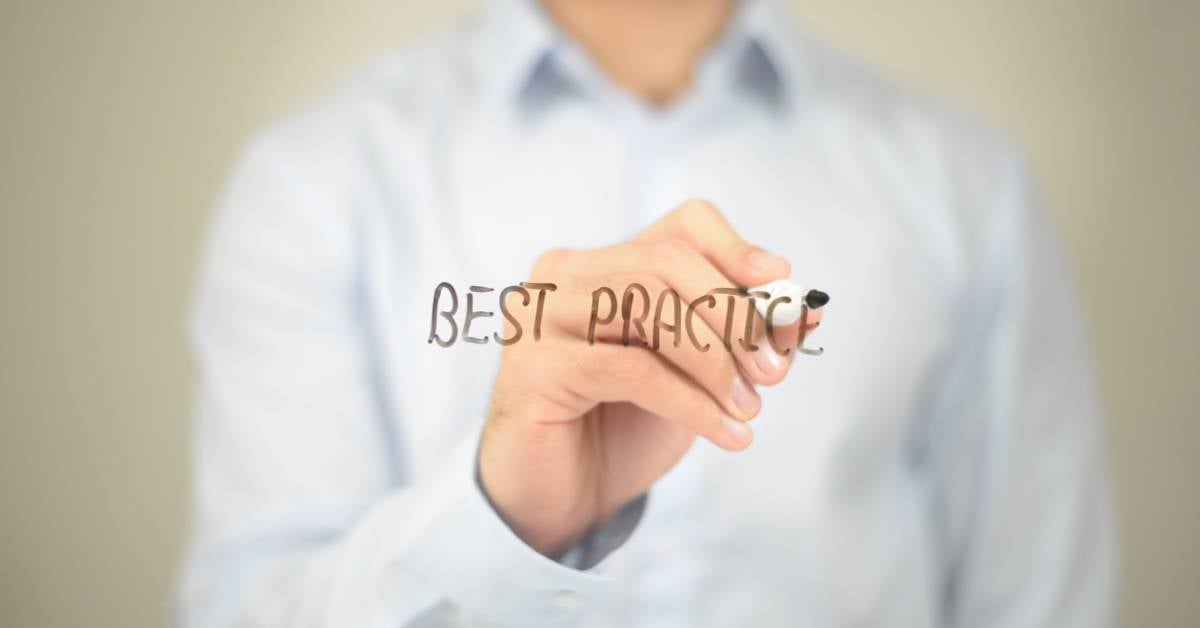 Business leader writing best practices on glass. 