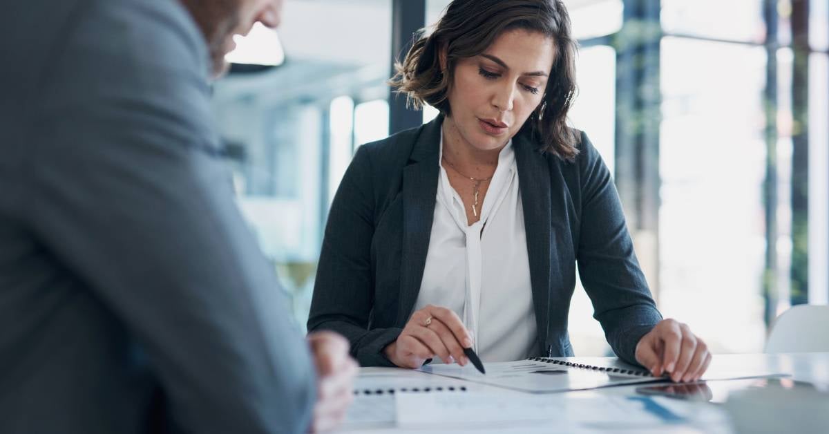 A female business leader goes over data with a male coworker.