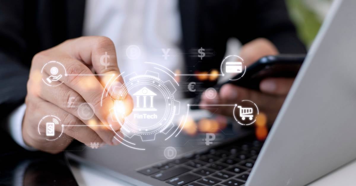 A closeup on a male executives hands-and-laptop-with-a-digitized depiction of financial regulations.