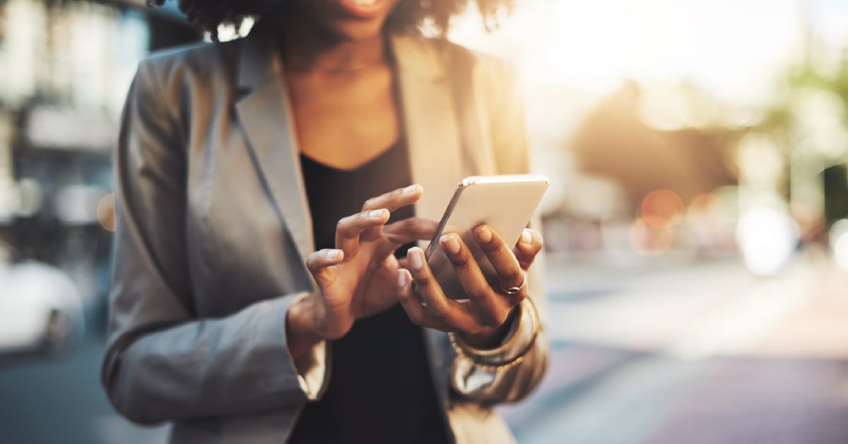 A woman uses her cell phone to access her business's communication tools from anywhere.
