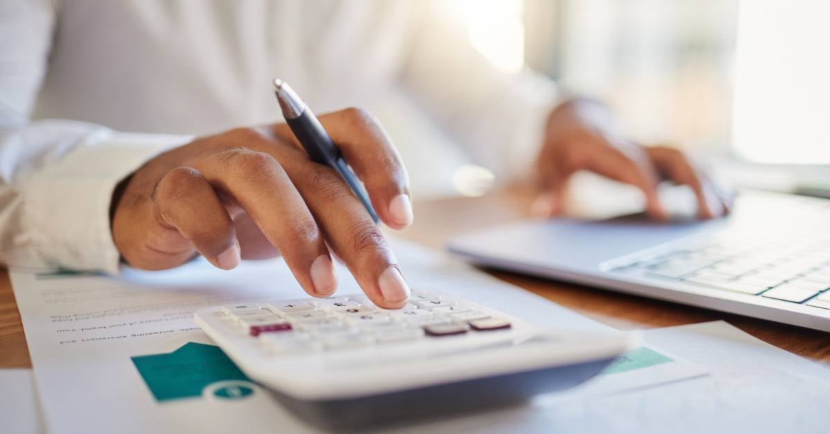 A closeup of a leader using a calculator.