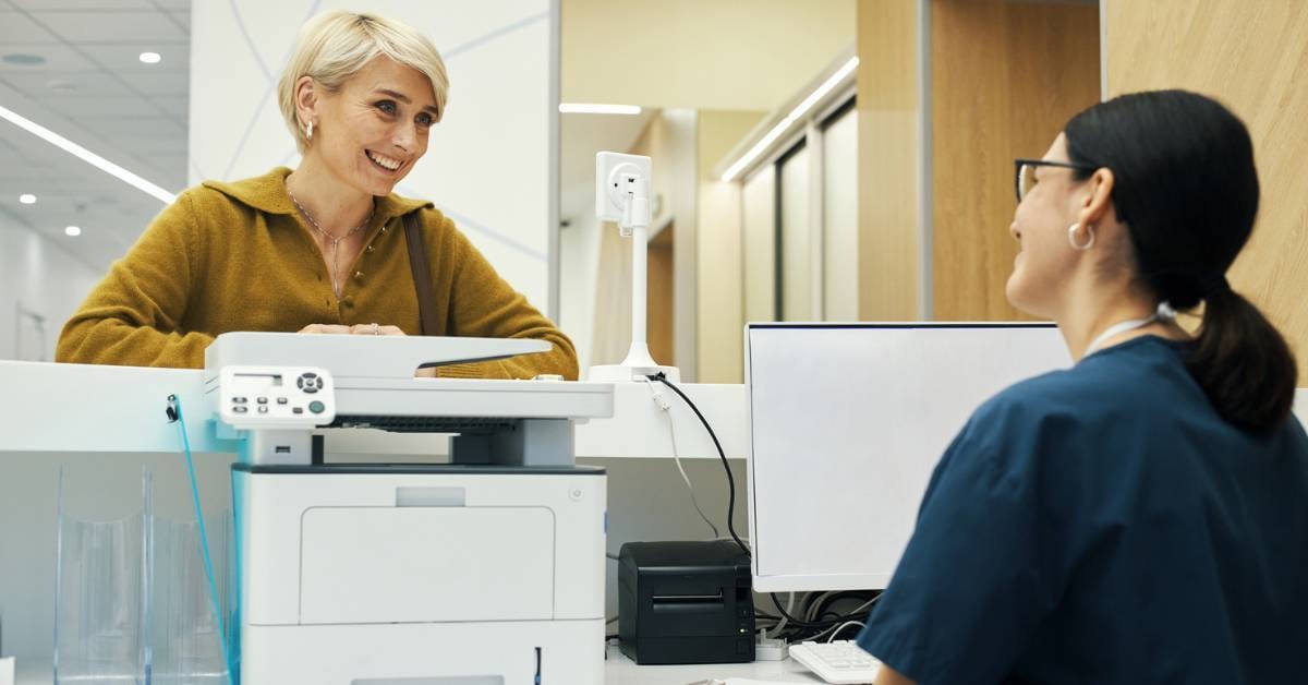 A businesswoman checks in at a healthcare front desk
