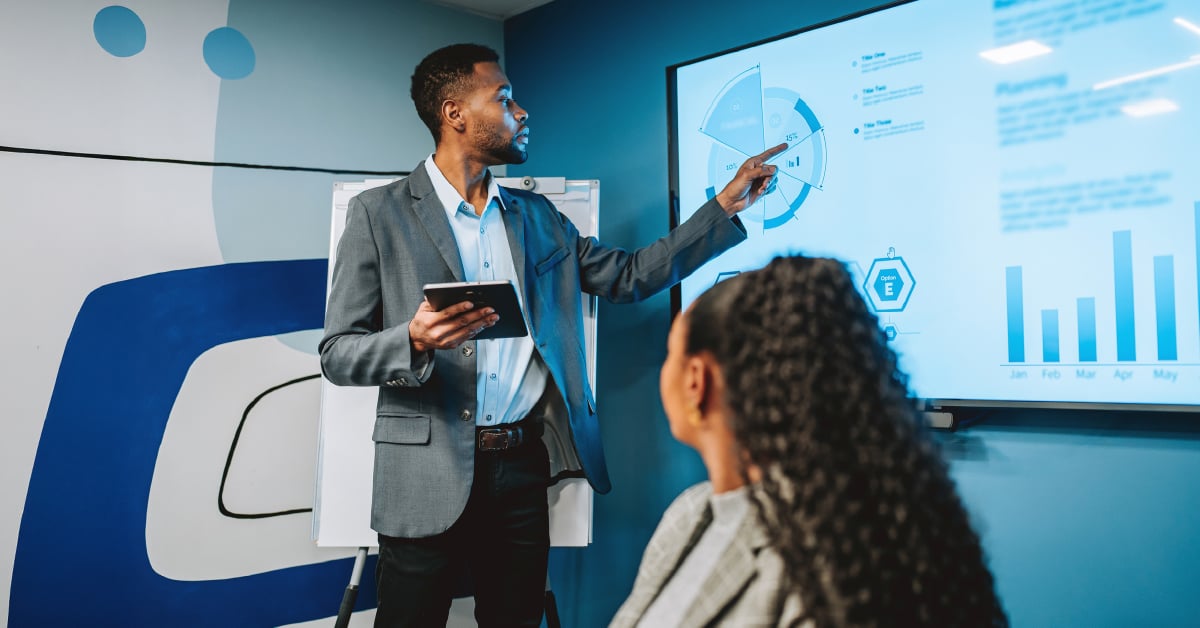 A cybersecurity partner presents data to a female owner of a small business.