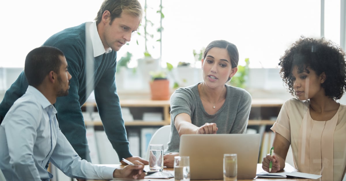 A business meeting where data is presented on a laptop.