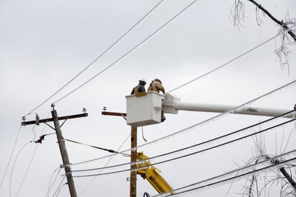 Electrical workers up in a bucket working on power lines