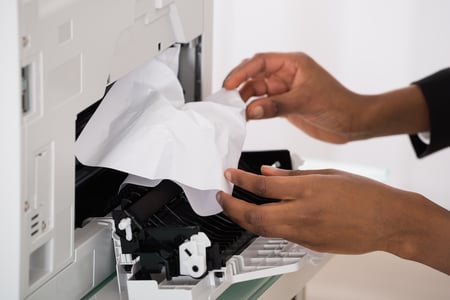 employee working with a paper jam from the copier machine