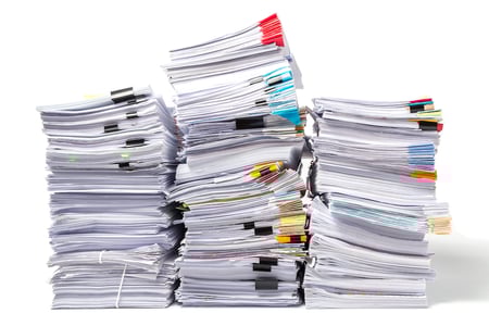 Image of three stacks of business documents with various colors of clips and tabs. 