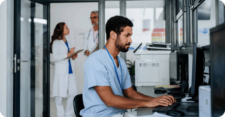 healthcare-worker-on-computer-with-doctors