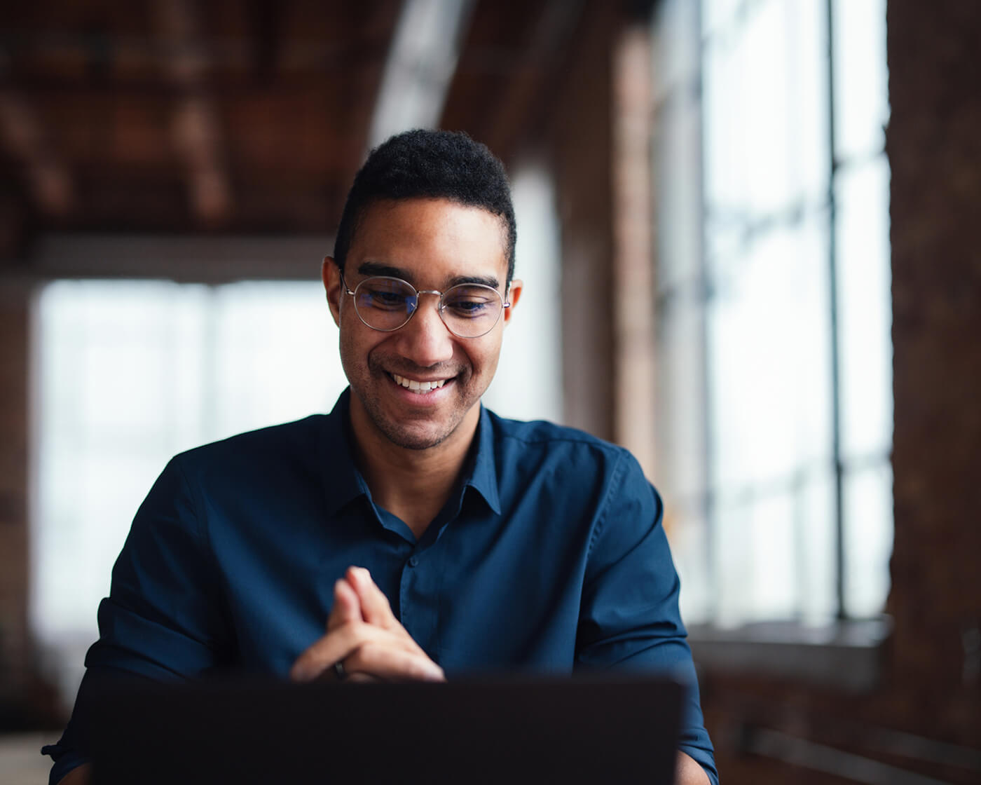 Businessman smiling while working on a laptop.