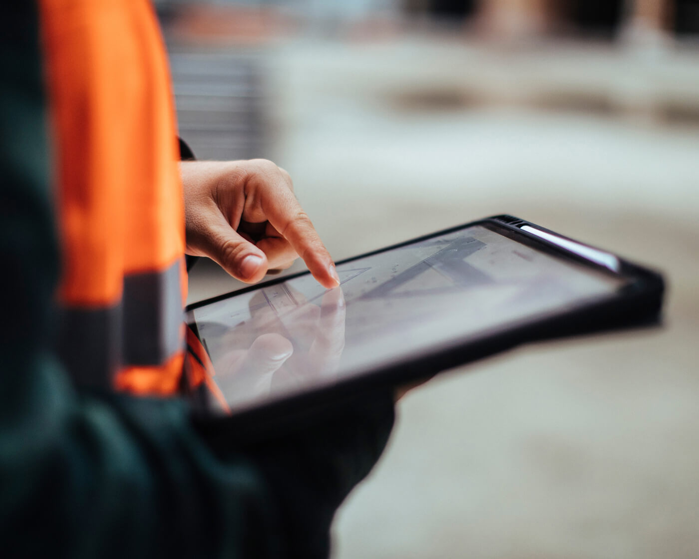 A construction worker uses a tablet to keep progress moving.