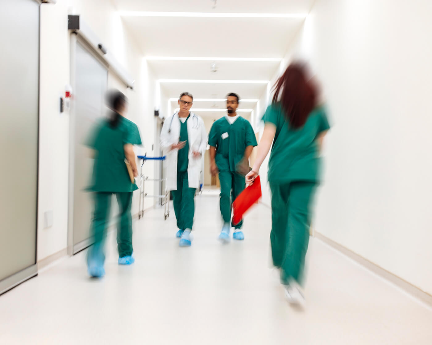Hospital staff move quickly through a corridor.