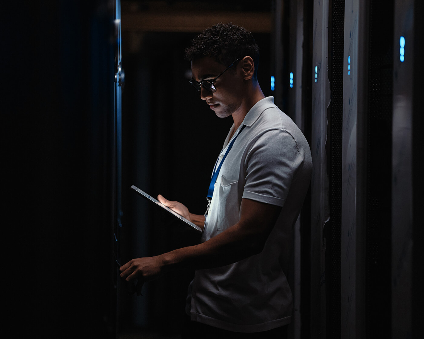 IT technician standing next to a server rack in a data center.
