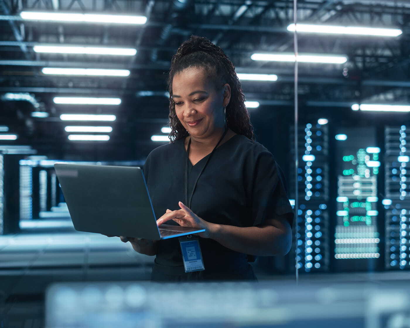Woman looking confident while working at a computer with security data on screen.