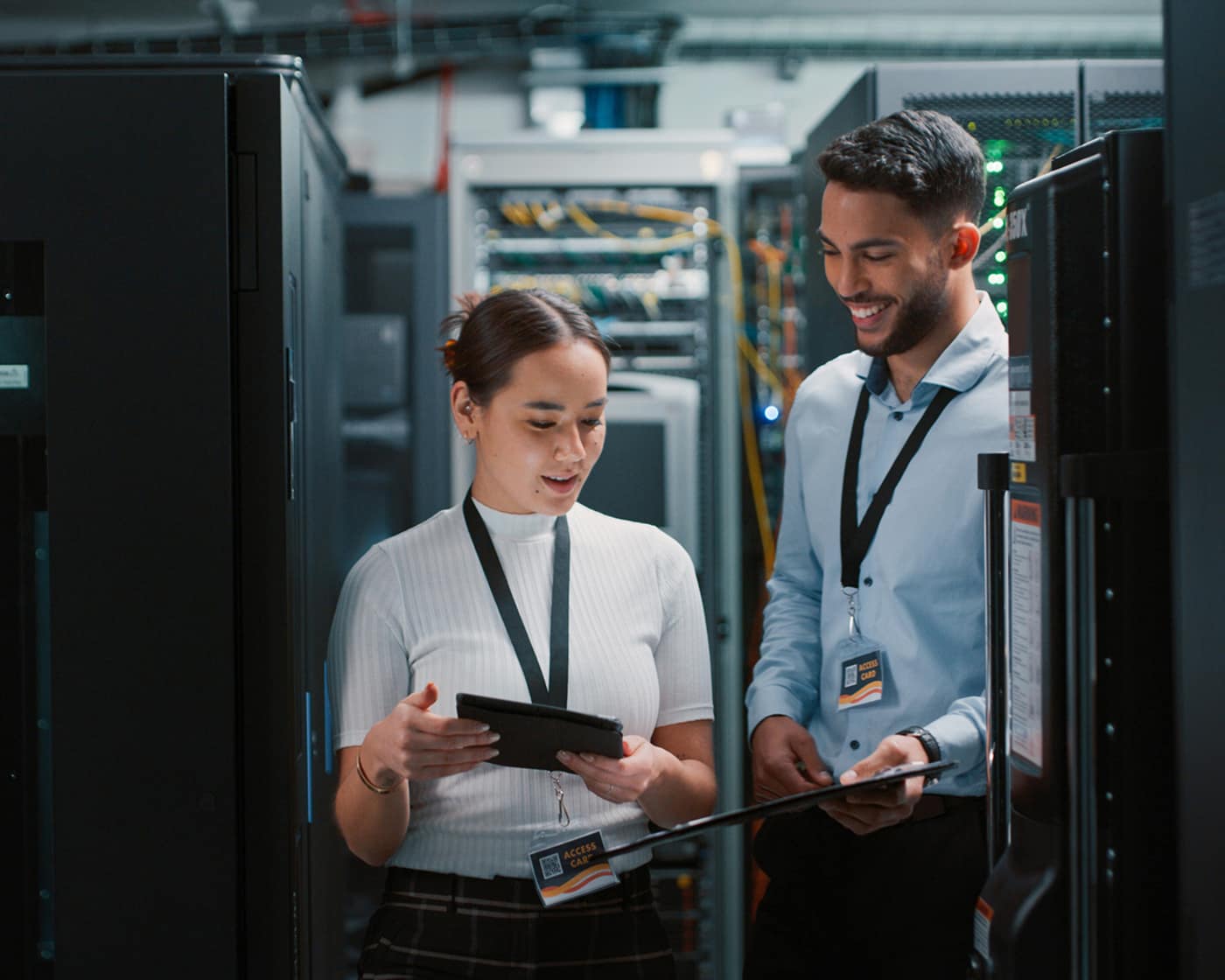 two-it-technicians-reviewing-tablet-in-server-room