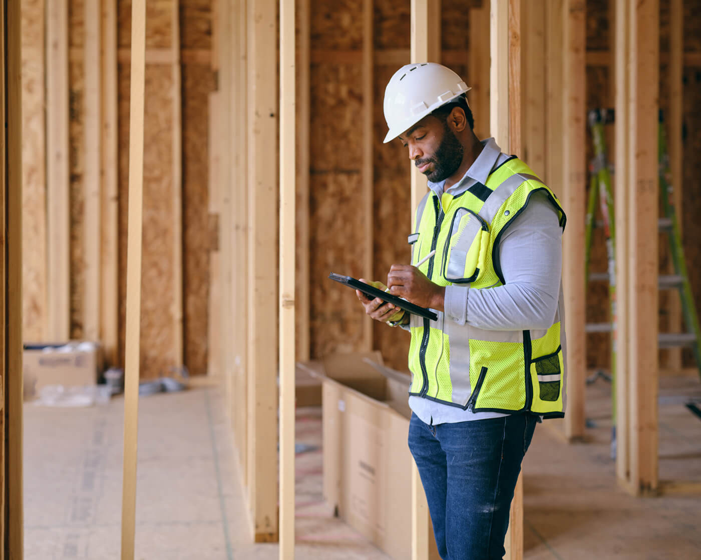 A construction worker using sophisticated software on a job site.