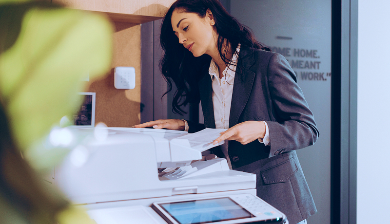 A businesswoman using a copier in a state government office.