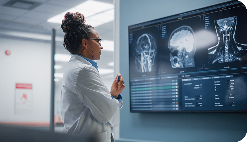 A doctor reviewing a brain scan on screen.