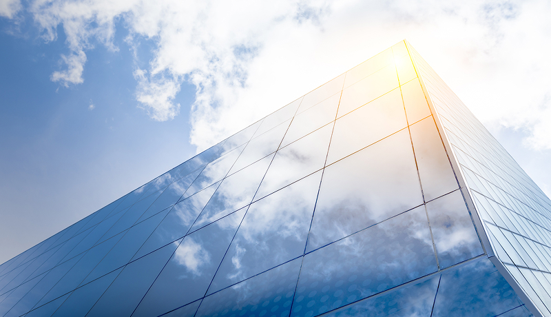Glass office building exterior viewed from below at an angle.