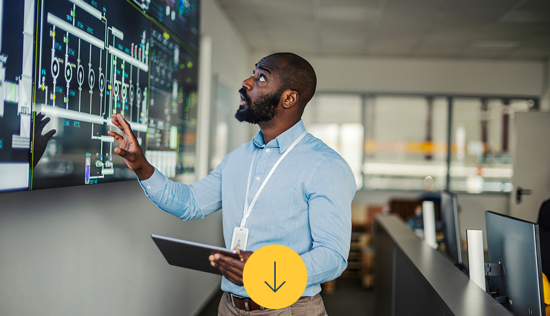 man-analyzing-automation-data-on-large-monitor-holding-tablet