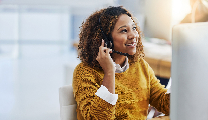 Close-up of a woman talking on a headset phone.