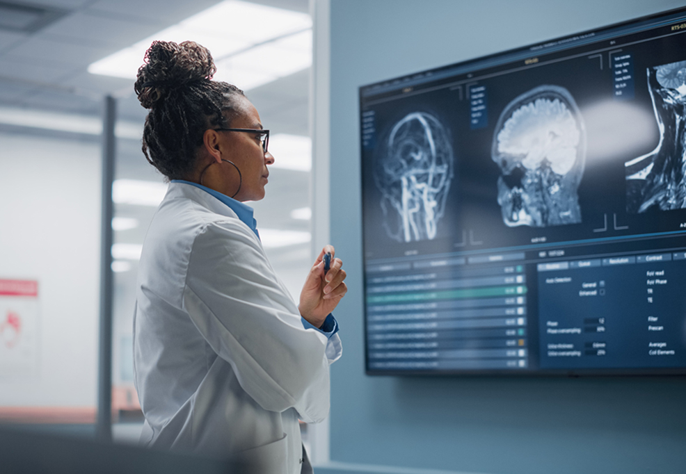 A woman studies an image of a human brain using advanced medical technology.