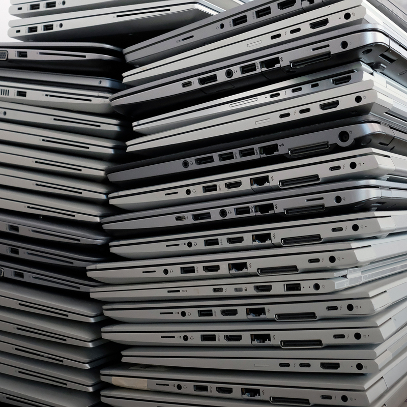 Stack of old electronic devices ready for secure disposal.