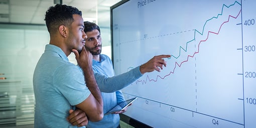 Two individuals looking at graph