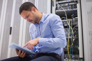 Man looking at a document while working on a server system
