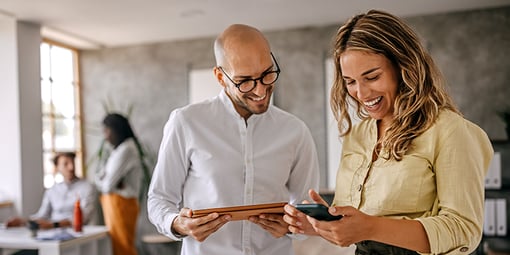 Man and woman looking at tablet smiling