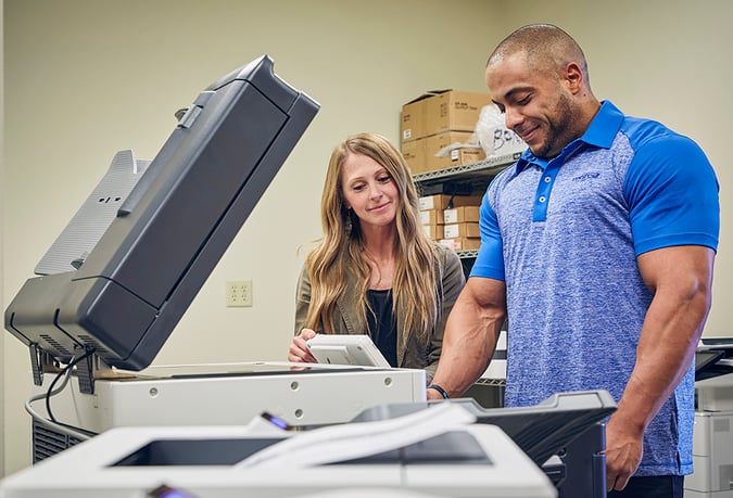 woman and man looking at open printer