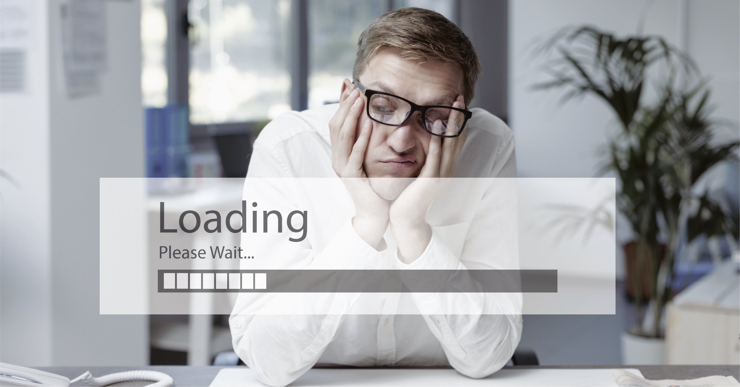 A stressed male employee waiting for their cloud tools to load, causing hidden productivity drains throughout their day.