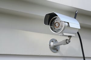 Digital video surveillance camera on the side of a business