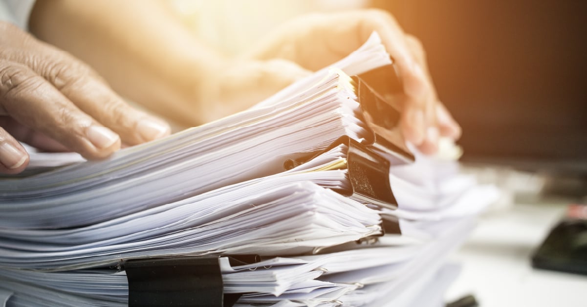 Person going through paper stack.