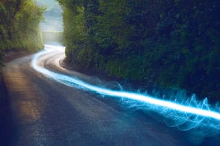 Image of a streak of light traveling down a road to represent high-speed