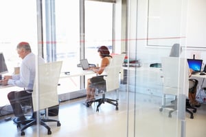 three people working in an open office space