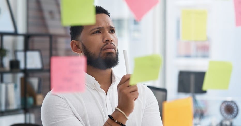 Employee making tough decisions using sticky notes. 