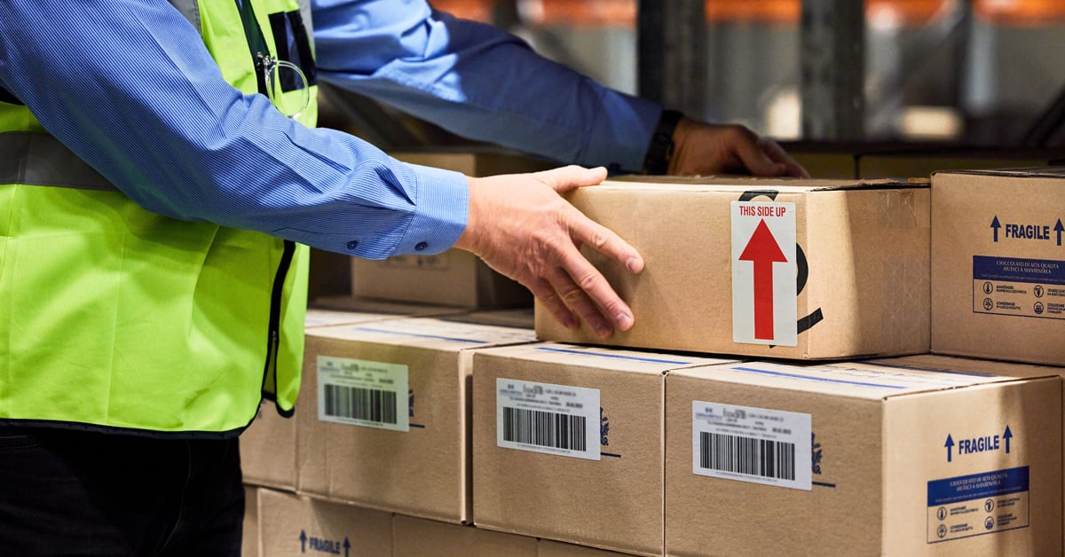 Warehouse worker stacking boxes.